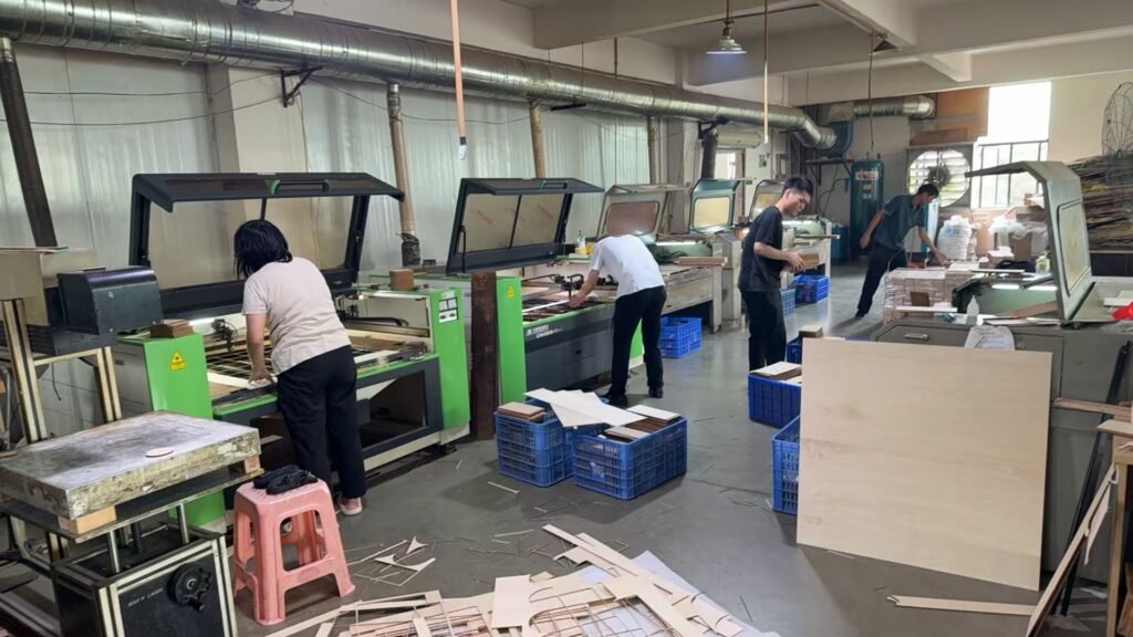 Worker operating laser cutting equipment for wooden crafts production